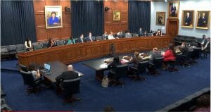A Congressional hearing room with members of Congress facing witnesses.