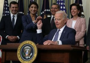 President Biden signs Executive Order On Promoting Competition In The American Economy and hands the pen to FTC chair Lina Khan.