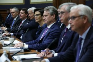 One woman CEO sits between six white men at a table.