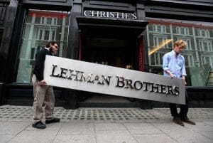 LONDON, ENGLAND - SEPTEMBER 24: Two employees of Christie's auction house manoeuvre the Lehman Brothers corporate logo, which is estimated to sell for 3000 GBP and is featured in the sale of art owned by the collapsed investment bank Lehman Brothers on September 24, 2010 in London, England. The "Lehman Brothers: Artwork and Ephemera" sale will take place on September 29, 2010, on the second anniversary of the firm's bankruptcy, and comprises of artworks which hung on the walls of Lehman Brothers' offices in Europe. (Photo by Oli Scarff/Getty Images)