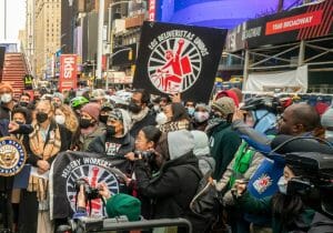 a group of people holding signs supporting delivery workers.