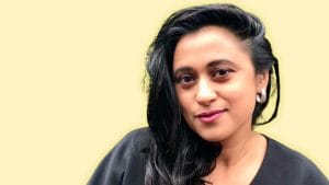 A woman with black hair looks at the camera