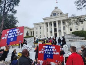 People hold signs saying "We are Alabama. We are UAW."