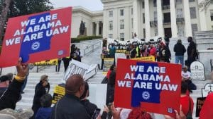People hold signs saying "We are Alabama. We are UAW."