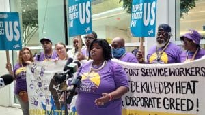A group of people hold a banner in support of airport service workers needing heat protections